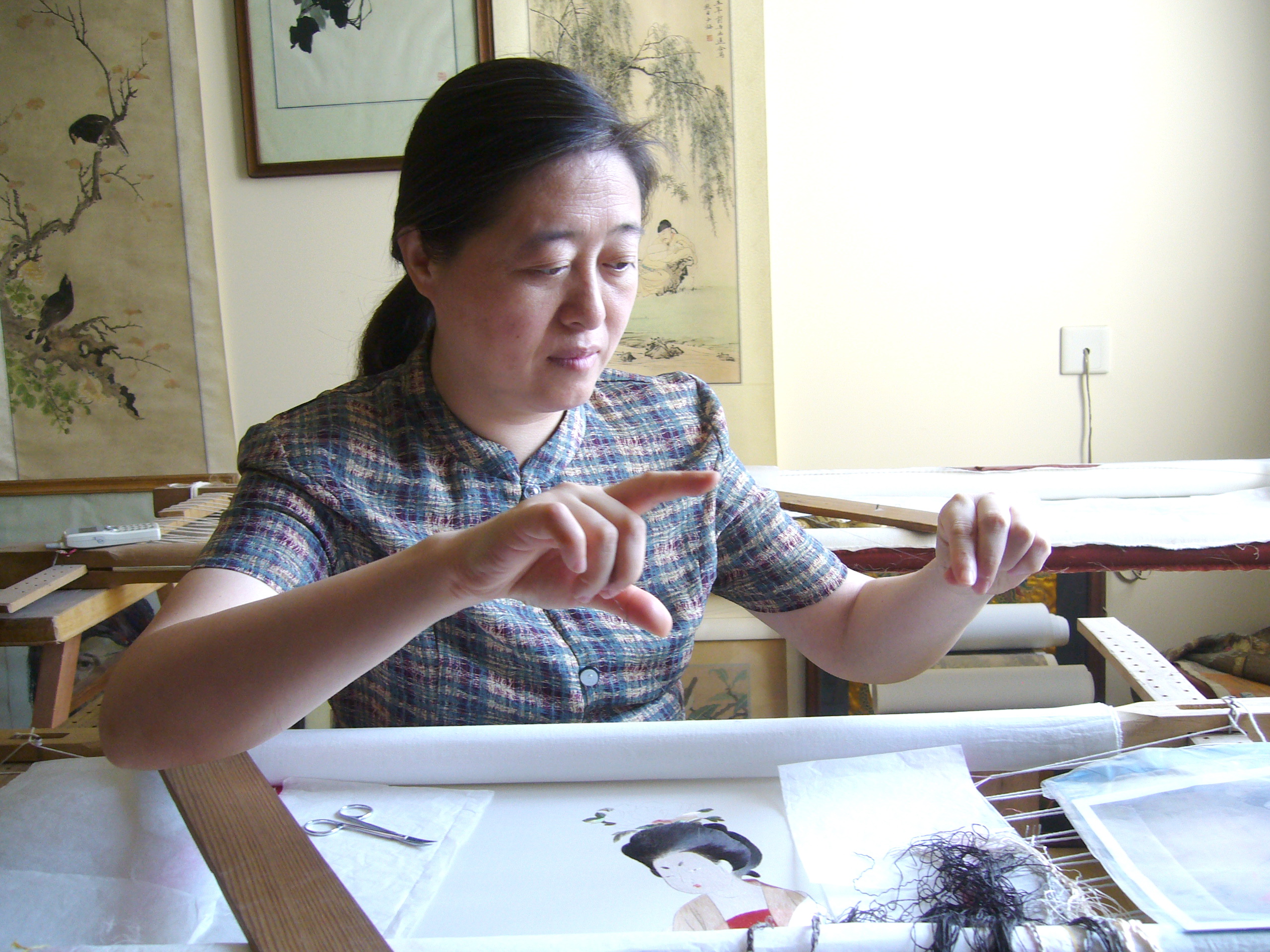 Shao Xiaoheng embroidering a lady with a flower pin