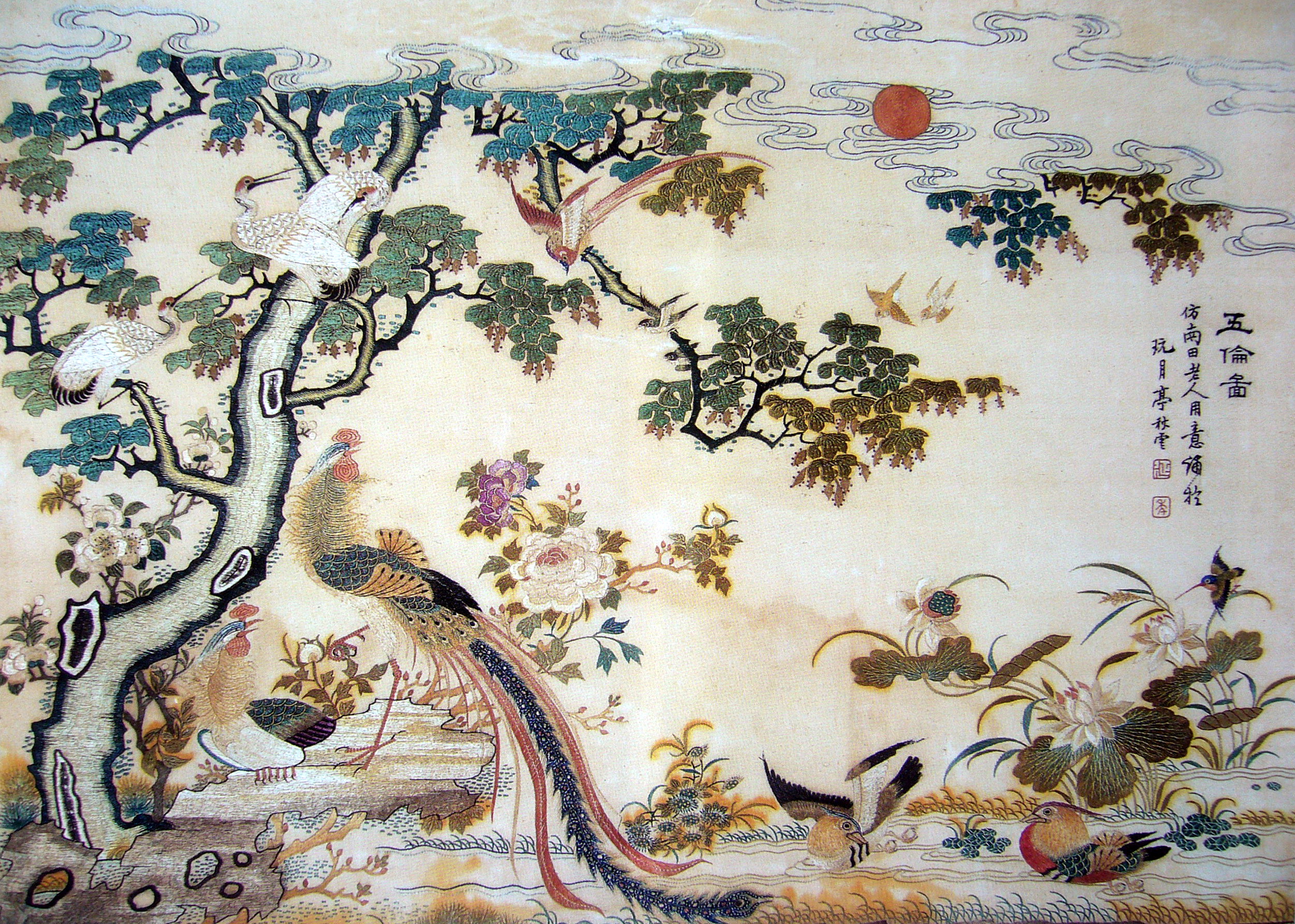 FIG. 30 Phoenix Facing the Sun Guangzhou Embroidery With classic patterns of Guangzhou Embroidery, this embroidered article has a typical style of the region’s embroidery. It is popular among people thanks to its connotation of auspiciousness, joyful celebration, blessing, and happiness. The phoenix is encircled by birds of various postures, along with the sun, clouds, Chinese parasol, peony, magnolia, purple vine, lotus flower, and camellia in reasonable space-distribution of immense magnificence. Embroiderers of Guangzhou Embroidery are good at leaving behind water-paths (i.e. empty fringe-lines), forming a bustling scene marked by clear veins, bright colors, and distinctive layers.